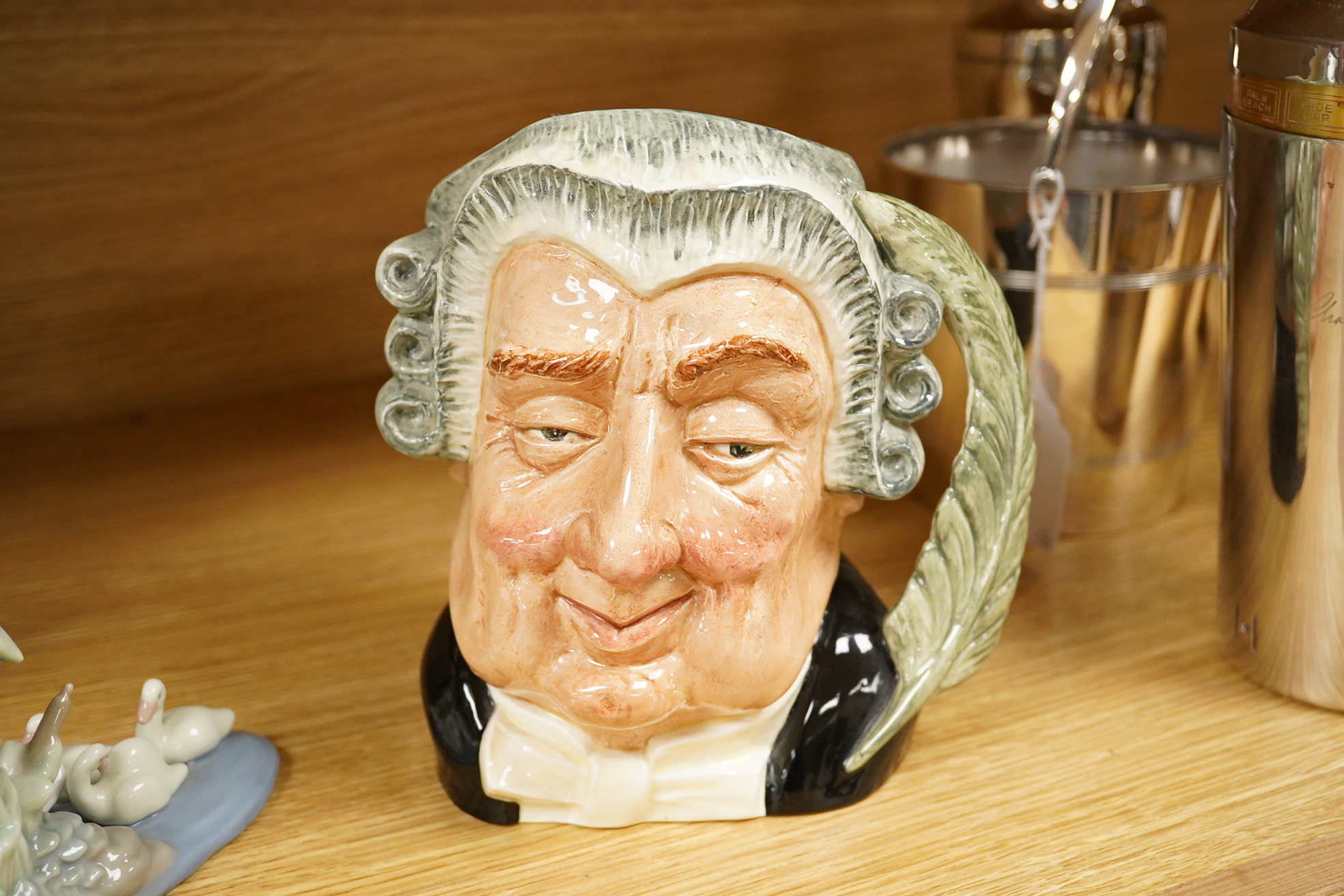 Four Lladro and Nao figures and a Doulton Toby jug, The Lawyer, largest 20cm high